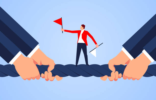 The referee stands in the middle of the rope of the tug of war